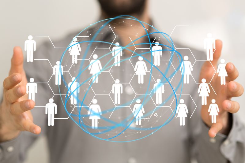 Business professional holding a digital network representing outsourced teams and business connections.
