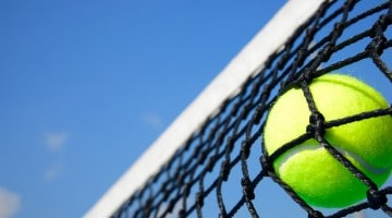 Tennis ball hitting tennis net