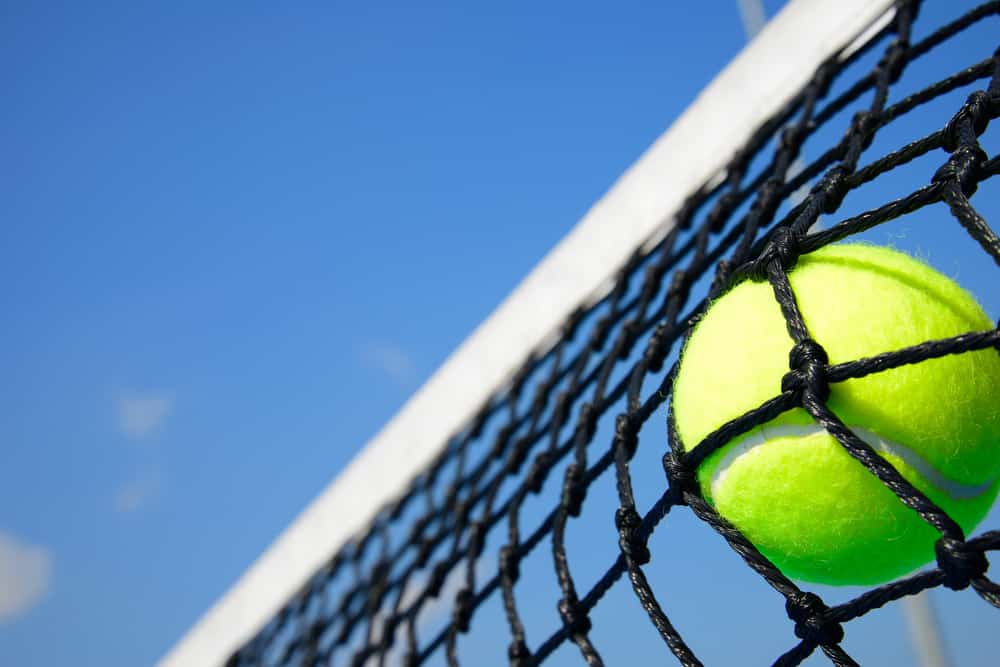 Tennis ball hitting tennis net
