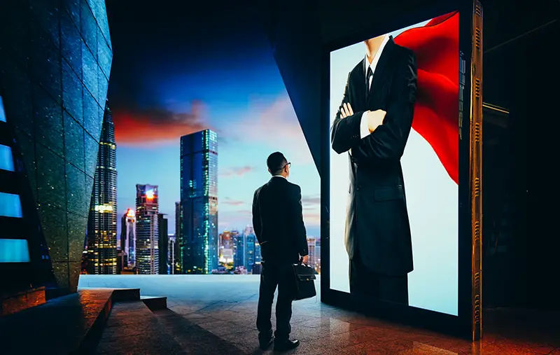 Young businessman looking the hero businessman on the advertising billboard screen