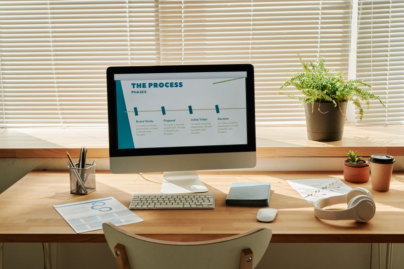 Horizontal image of workplace of business person with computer monitor on it and program on screen at modern office