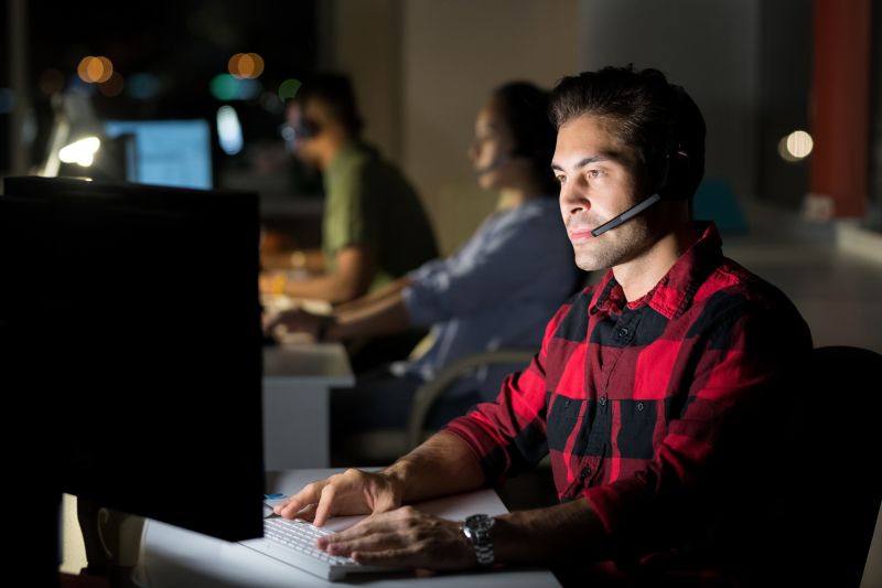Professional Man Works Late in a Call Center