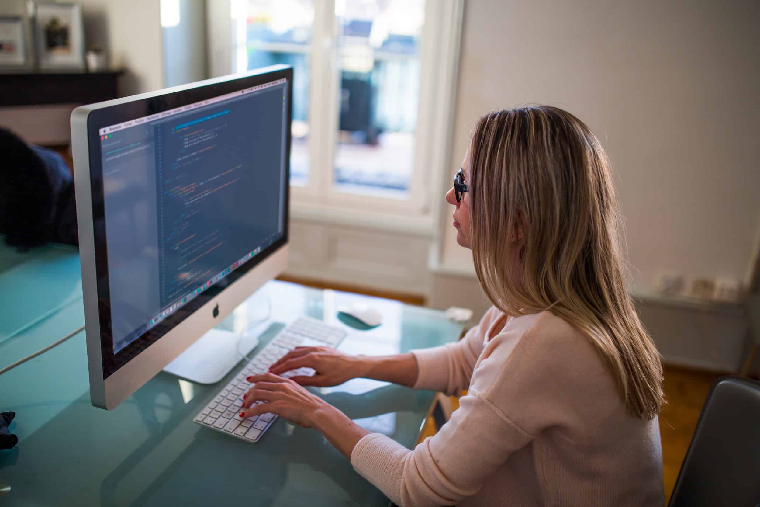 Blonde hair Woman wearing eyeglasses working on her computer