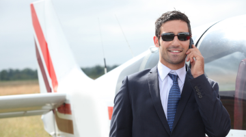 Man talking on a mobile phone next to a private plane
