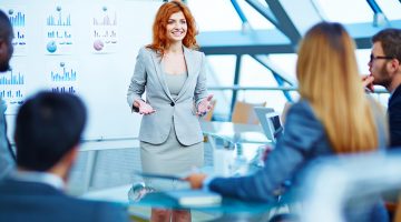 Professionally-trained manager explaining her point of view to colleagues at meeting