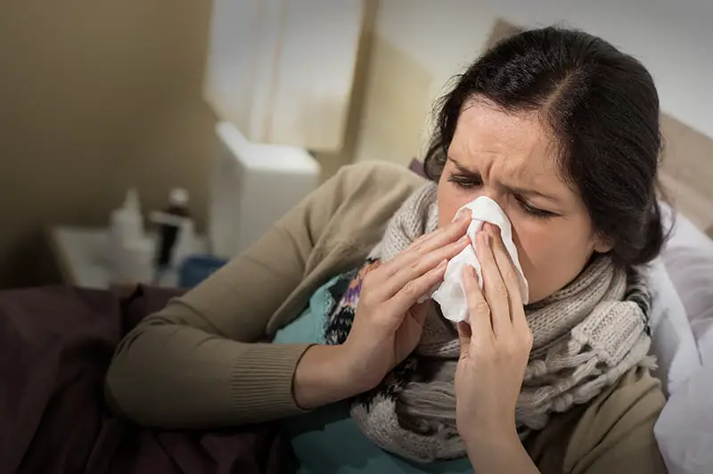 Keep Sick Leave Under Control During the Festive Season - Caucasian woman having bad cold blowing her nose