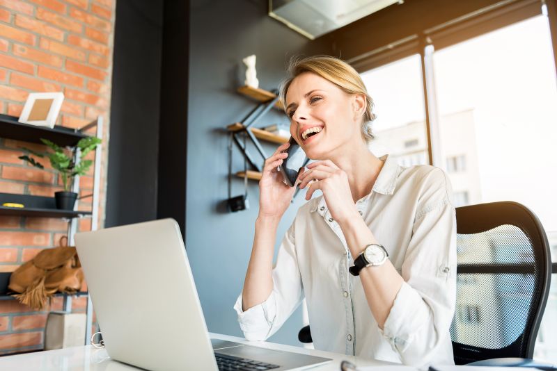 Smiling Woman Working at Desk with Laptop