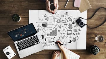 flat lay photography of mac book pro beside notebook paper and camera