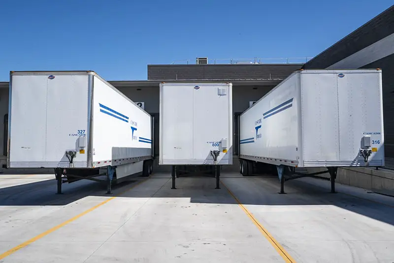 three white enclosed trailers