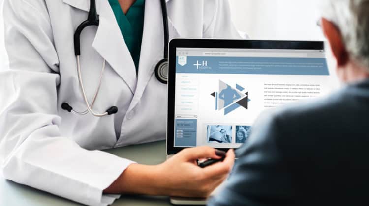 doctor pointing at laptop screen showing it to patient