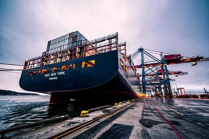 Black container ship at dock