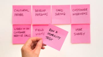 person holding pink post it sticky note