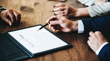 close up of people signing a document