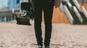 Photographer/videographer holding camera on the beach