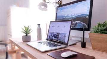 MacBook Pro on table beside white iMac and Magic Mouse showing SEO results