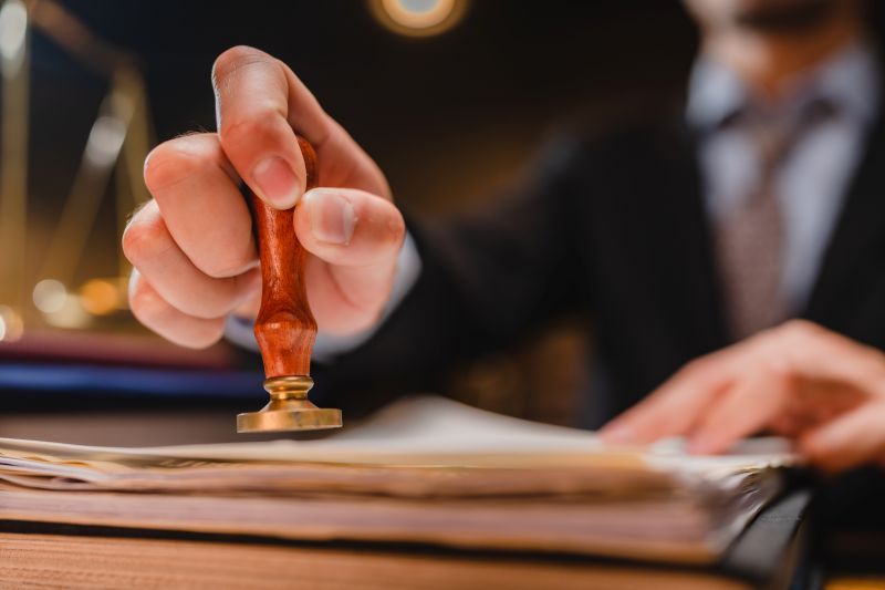 businessman or lawyer put a success stamp on legal deal contract in office, approved on certificate