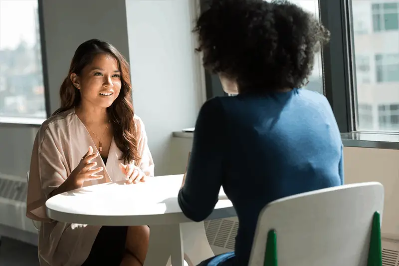 Acing the job interview - two women  sat at a round white table
