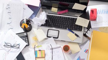 clutter untidy desk - chaos - office organization required.