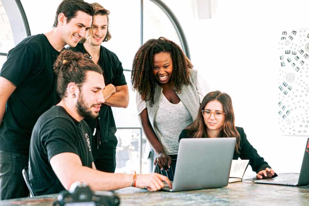 Happy Millennial Employees looking at a laptop computer