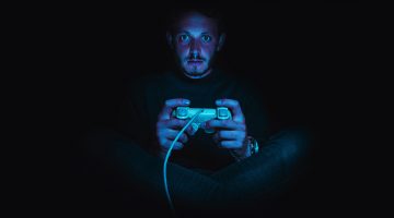 Gamer holding controller playing indie game