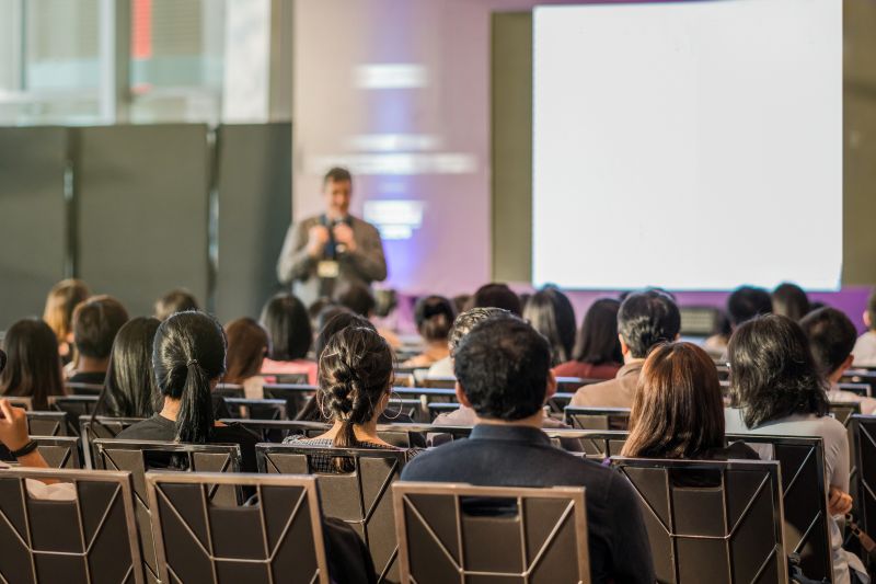 Rear view of Audience in the conference hall or seminar meeting which have speaker