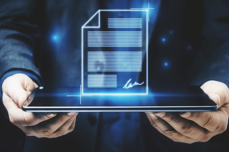 Close Up Of Businessman Hands Holding Tablet With Abstract Digital Document Hologram.