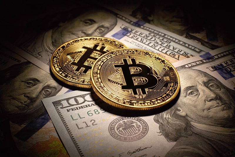 Bitcoins lying on US dollar bills - currency, cryprocurrency
