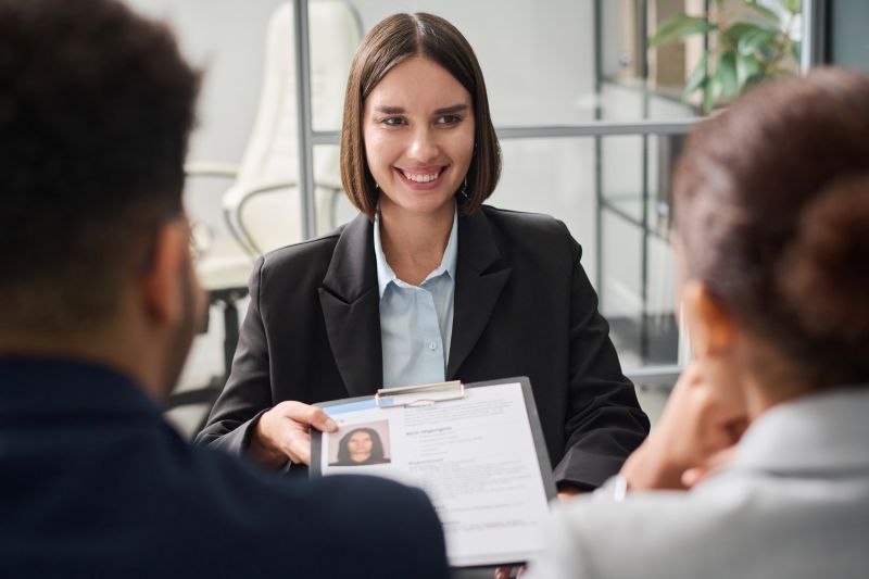 Smiling young specialist having interview with applicants during meeting in office