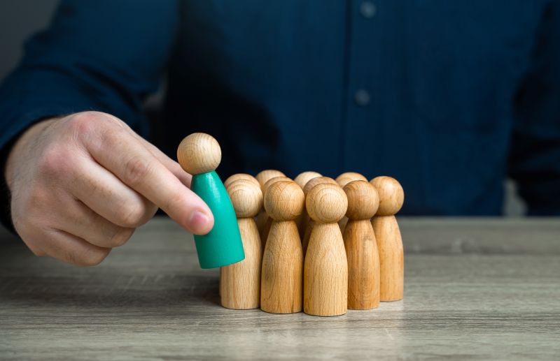 Business Leadership Concept with Wood Figures and Hand