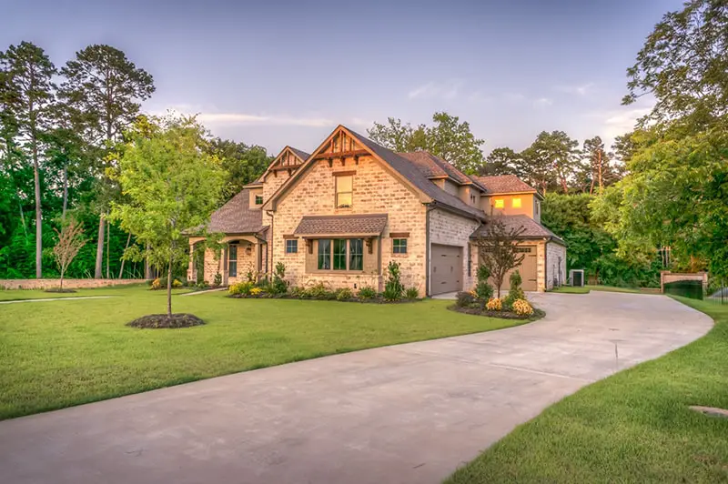 driveway leading to brick house set in landscaped garden