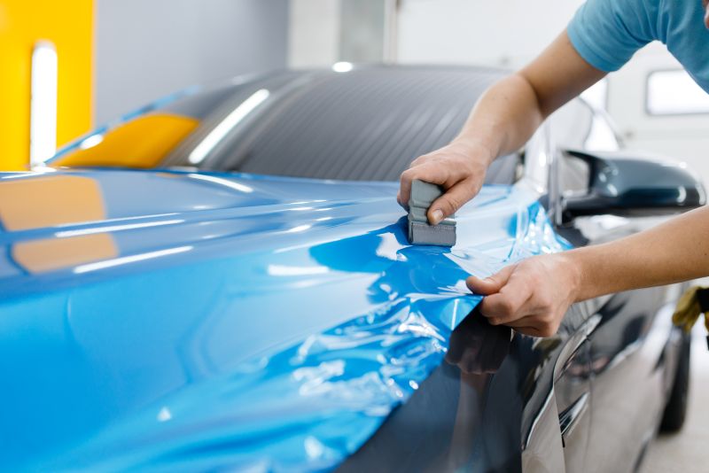 Applying Bright Blue Vinyl Wrap to Luxury Car