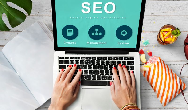 SEO on Laptop with Hand Typing in Workplace