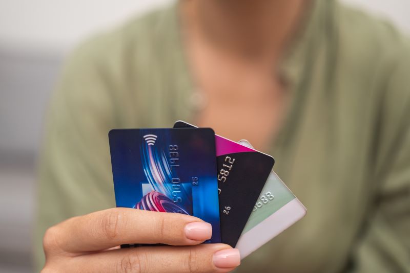 Close-up: Woman hand grasps stack of credit cards, symbolizing online payments, shopping
