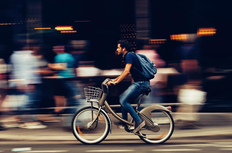 man riding bicycle – e-bike on city street