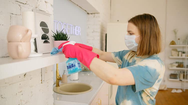A woman wearing facemask while cleaning