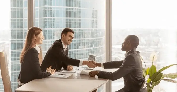People shaking hands at in an office - enterprise customer support