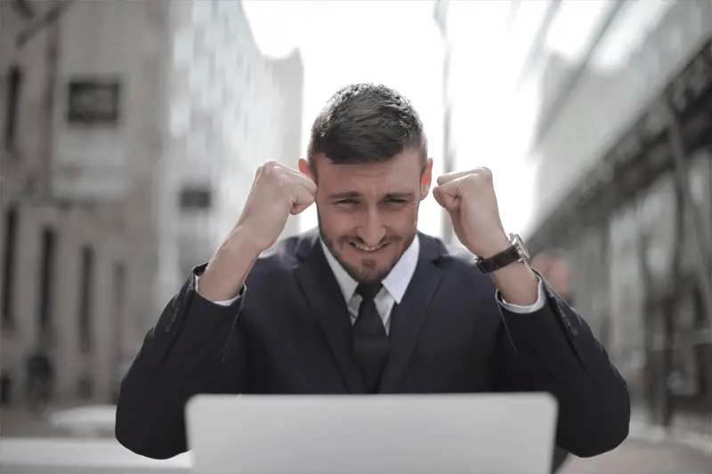 man in suit with fists  pumped celebrating an accomplishment - business success

