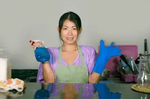 An asian woman wearing blue gloves