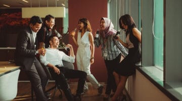 A group of people laughing while having drinks