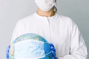 A nurse with eyeglasses wearing facemask while holding a globe