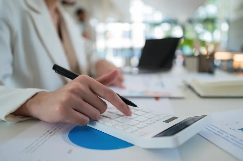businesswoman accountant using calculator and laptop for matching financial data saving in office room
