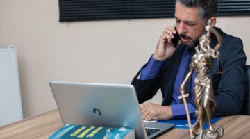 A lawyer on call while working on his gray laptop