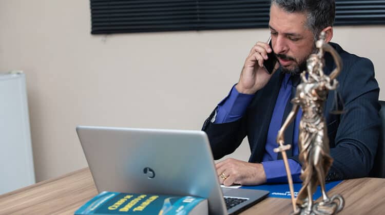A lawyer on call while working on his gray laptop