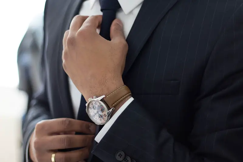 businessman in suit adjusting his tie