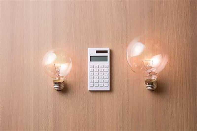 white calculator in between two light bulb on wooden table