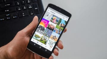 Person holding black smartphone with instagram apps on the screen