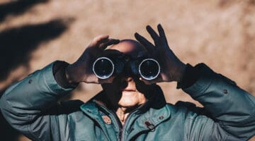 Private investigator using binoculars