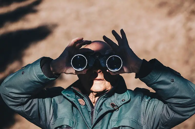 Private investigator using binoculars