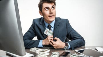 A man putting paper bills inside his coat