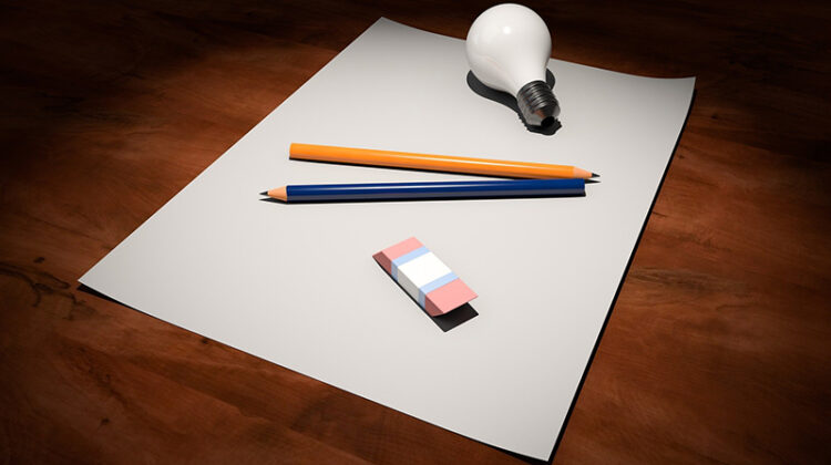 White bod paper, pencil and bulb on the top of wooden table